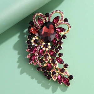 Vintage floral brooch with large oval burgundy gemstone and rhinestone accents on gold base