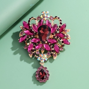 Vintage gold alloy brooch with purple rhinestones and large drop-shaped gemstone