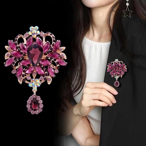 Elegant purple crystal flower brooch with water drop pendant on a black blazer