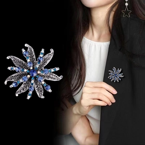 Detailed macro of vintage star flower brooch with blue rhinestones on silver metal