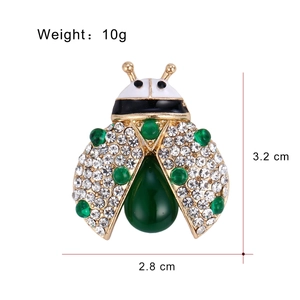 Élégante broche coccinelle en alliage doré avec strass blancs et cristal vert