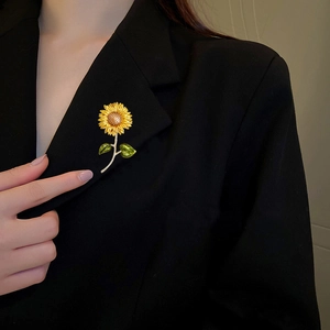 Fashionable sunflower brooch with yellow enamel petals on a black suit lapel