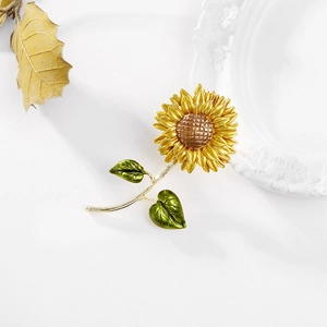 Elegant 3D sunflower brooch featuring yellow enamel petals and golden metal leaves