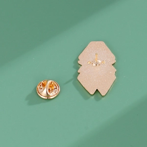 Detail of golden metal brooch back featuring secure butterfly pin clutch fastener