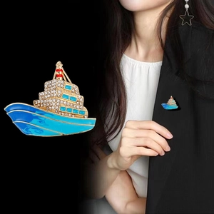 Vue détaillée d'une broche paquebot en émail bleu et strass sur un revers noir
