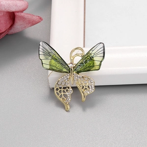 Détail de la broche papillon verte avec cadre en alliage doré et strass blancs brillants