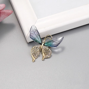 Broche papillon dorée élégante avec ailes en résine bleu dégradé et petits diamants
