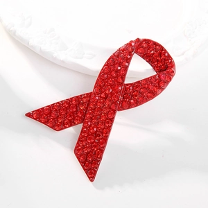 World AIDS Day awareness brooch featuring red crystals in a ribbon design on white plate
