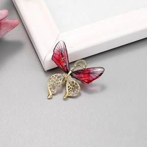 Broche papillon élégante aux ailes rouges dégradées et strass brillants sur cadre doré