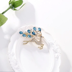 Élégante broche cerf doré ornée de cristaux blancs et pierres bleues sur cadre blanc
