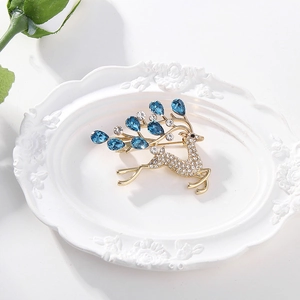 Broche élan dorée élégante avec diamants scintillants et gouttes de pierres bleues