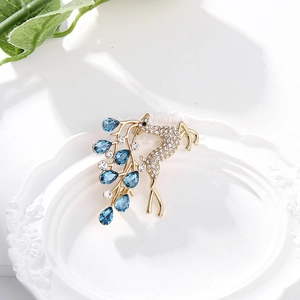 Élégante broche cerf dorée avec gouttes de cristal bleu et zircons étincelants