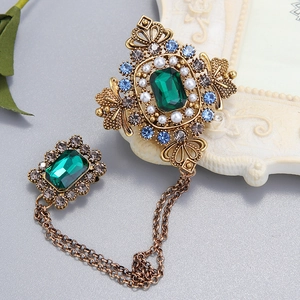 Détail d'une broche baroque avec émeraude, chaînes en or antique et des perles