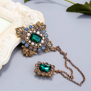 Broche baroque émeraude avec chaînes en cristal et finition dorée vintage rétro