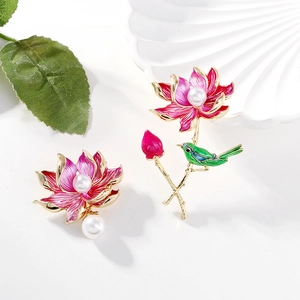 Vintage lotus and bird brooch set with pearls and pink enamel on a white background