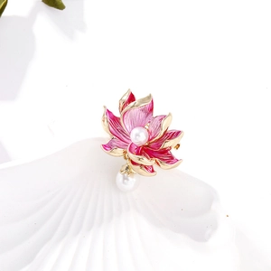 Elegant pink enamel lotus flower brooch with pearls in a white seashell display