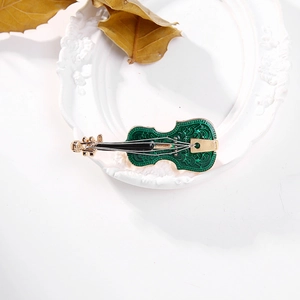 Detailed macro view of an artistic green enamel violin brooch with golden metal textures