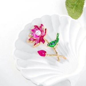 Elegant lotus and bird brooch with pink petals, green enamel, and a white pearl accent