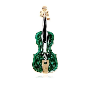 Golden violin brooch with green enamel and hollow pattern on a white background