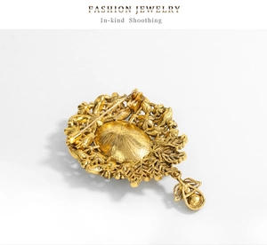 Detail view of the vintage gold brooch back featuring pin fastener and metal texture
