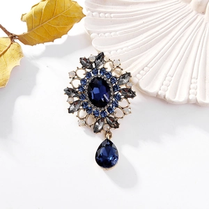 Broche dorée vintage avec grand cristal bleu ovale et pendentif goutte d'eau