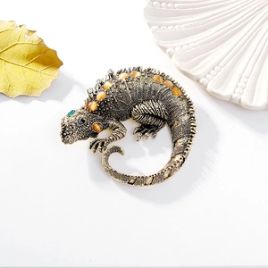Vintage lizard brooch with amber gems and green accents on a textured gold finish
