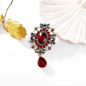 Broche vintage dorée avec cristal rouge, pierres facettées et pendentif goutte sur plateau