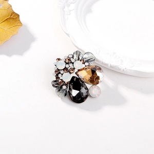 Elegant vintage teardrop crystal brooch with amber and black stones on white background
