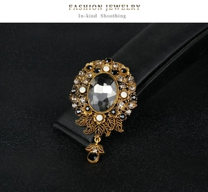 Macro detail of Victorian vintage brooch with dark oval stone and waterdrop pendant