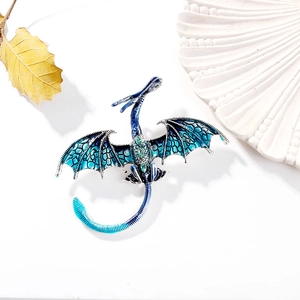Détail de la broche dragon en émail dégradé bleu avec ailes serties de zircons verts