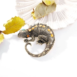 Detail of vintage lizard brooch with amber rhinestones on an autumn leaf background