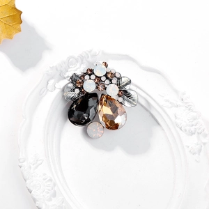 Detail of vintage crystal brooch with amber and black teardrop stones on floral frame