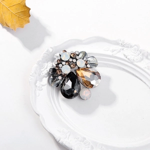 Macro shot of vintage crystal brooch with amber stones on elegant white tray