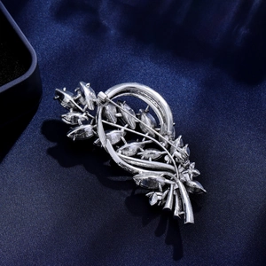 Vintage silver flower cluster brooch featuring marquise crystals on dark silk background