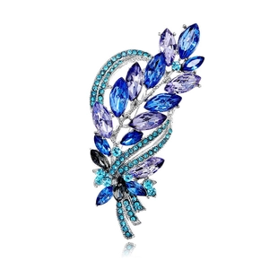 Vintage leaf-shaped brooch with blue and purple crystals on a silver metal base
