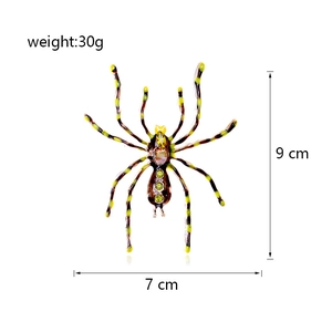 Detail view of large spider brooch showing 9cm by 7cm dimensions and green crystals