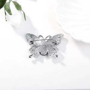 Detailed back view of silver butterfly brooch showing secure pin fastener and texture