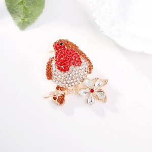 Elegant gold bird brooch with vibrant red and orange rhinestones on flower branch