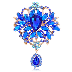 Macro view of blue crystal brooch with pear-shaped stones and gold alloy base