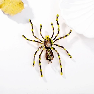 Vintage spider brooch with opal stone and green rhinestones on white background