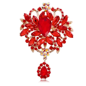 Macro detail of red teardrop crystals and gold alloy setting on vintage floral brooch