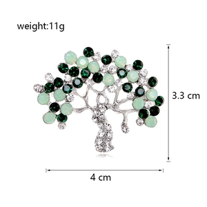 Detail showing an alloy tree brooch with green crystals, dimensions 3.3cm by 4.0cm
