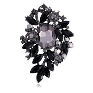 Macro shot of oval grey gemstone brooch with black rhinestone floral petal details