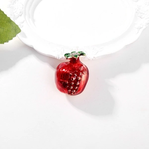 Exquisite red pomegranate brooch pin with green enamel leaves on white plate