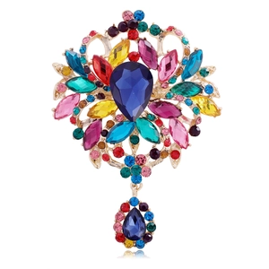 Elegant gold-tone brooch featuring a blue teardrop stone and multi-colored rhinestones