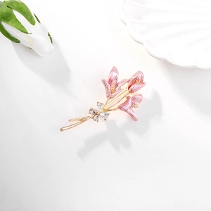 Détail de la broche fleur de lys rose avec dorure et accents de pierres de zircon