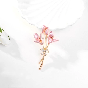 Détail macro d'une broche lys avec pétales en émail rose et strass blancs fins