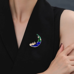 Broche croissant de lune élégante avec château émaillé bleu et cristaux sur blazer noir