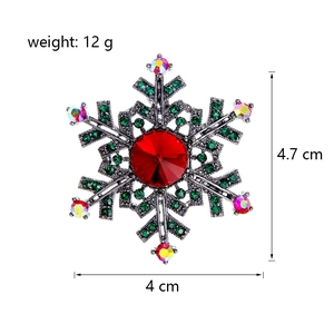 Detailed macro view of snowflake brooch with red ruby center and dimensions
