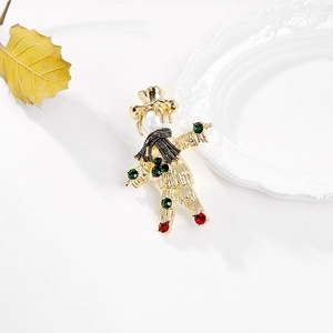 Vintage scarecrow brooch in gold alloy with colorful crystals and pearl on white background